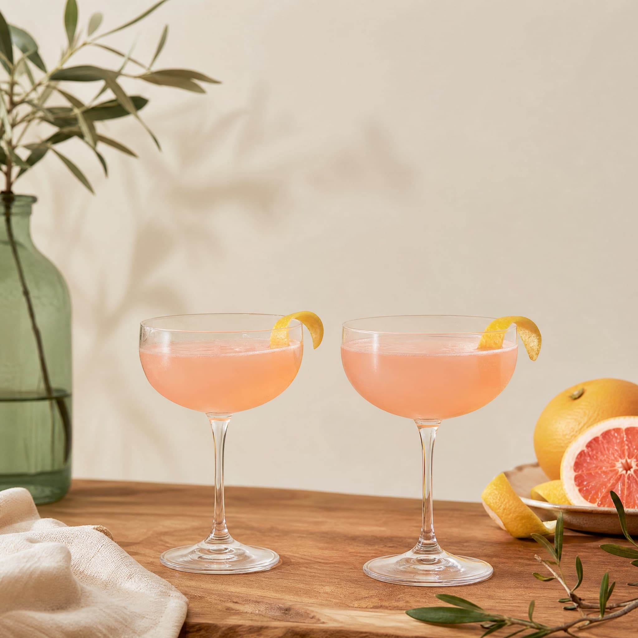 Coupe Glass Duo arranged on a warm cream surface